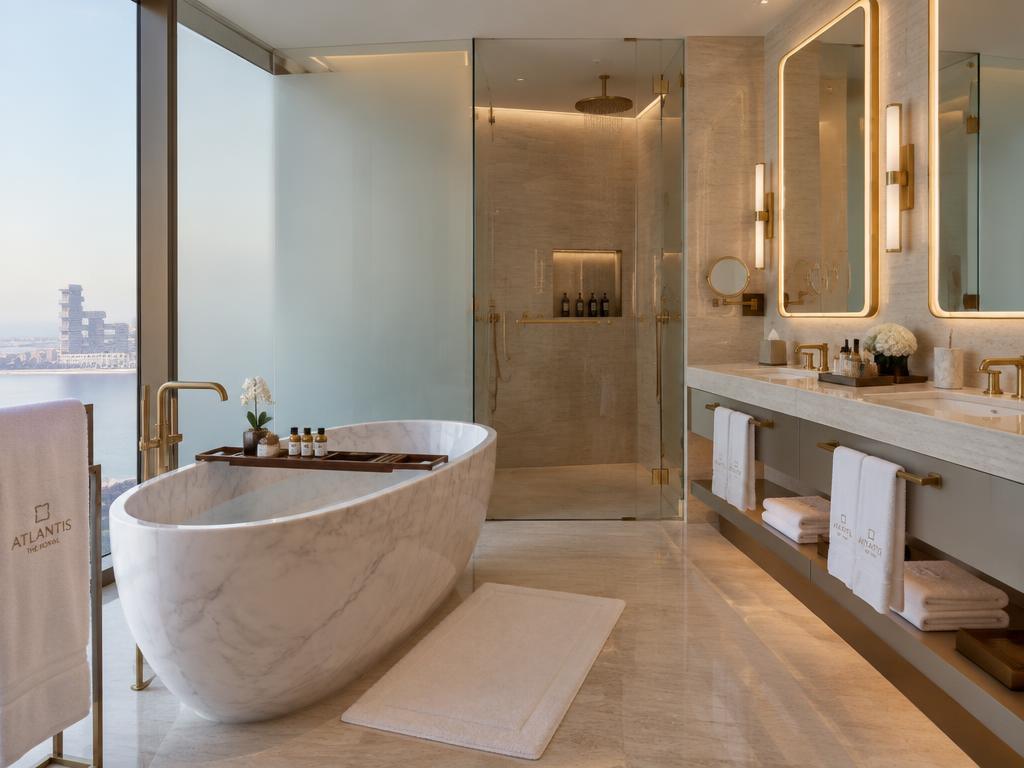 Marble soaking bathtub and rain shower with Gulf skyline views